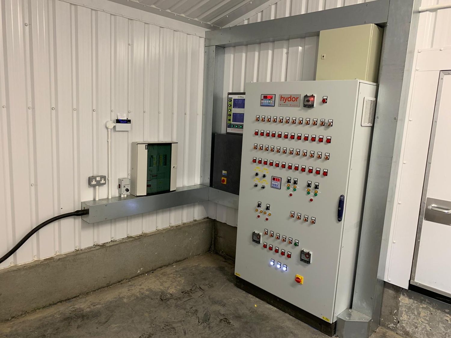 Electrical containment installed along a broiler shed wall